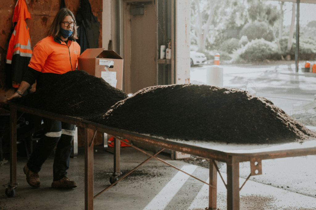 A large pile of soil getting put out on a table for quality testing