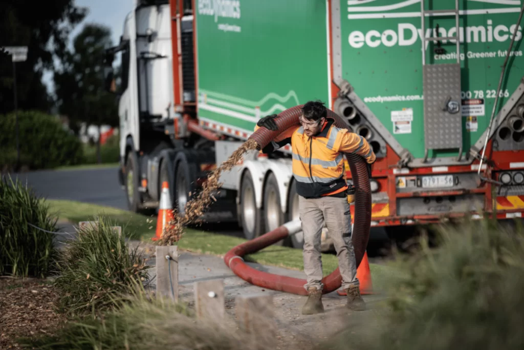 an ecoDynamics worker blowing mulch using a mulch blower