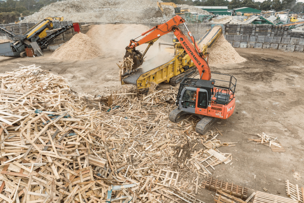 A large bulldozer moving mulch which shows how much recycled mulch we make