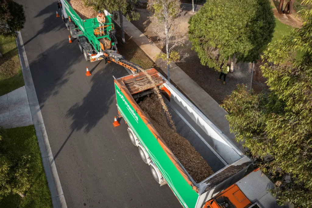 a slinger truck with mulch getting filled into it