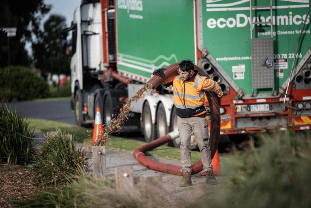 This is a blower truck being used to blow mulch onto the ground to create a beautiful landscape