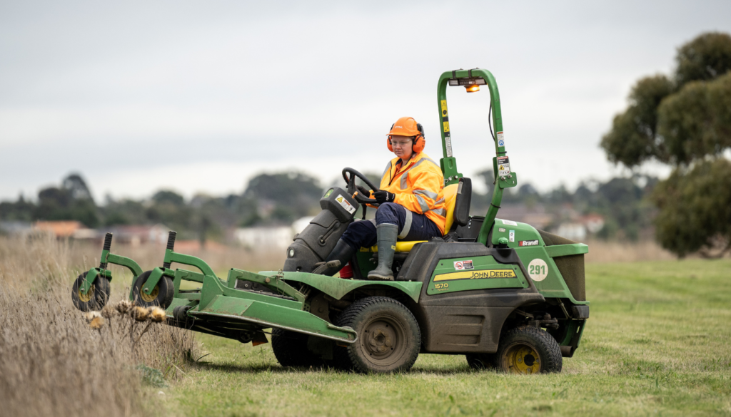 Female employee driving a ride-on-mower that shows our commitment to boosting female employment
